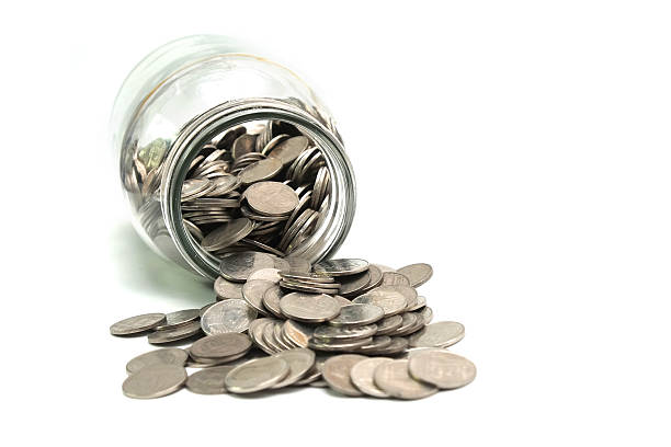 istock Jar of thai coins spilled on a white background 495697174
