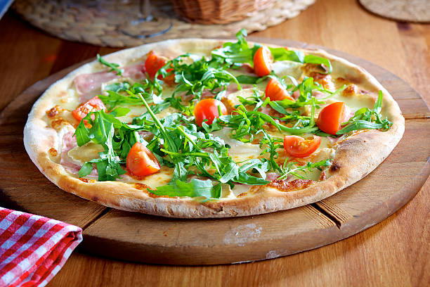 istock Pizza with rocket salad, ham and cherry tomatoes 495697975