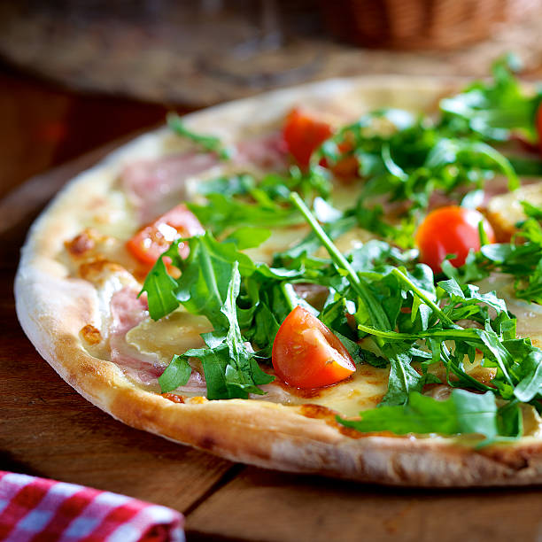 istock Pizza with rocket salad, ham and cherry tomatoes 495697977
