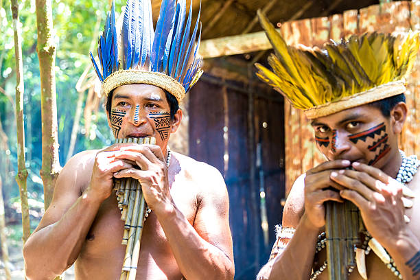 istock Native Brazilian men playing wooden flute 495698038