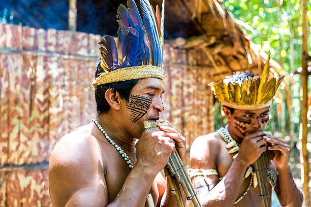 istock Native Brazilian men playing wooden flute 495698210