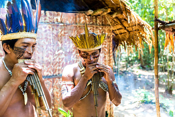 istock Native Brazilian men playing wooden flute 495698346