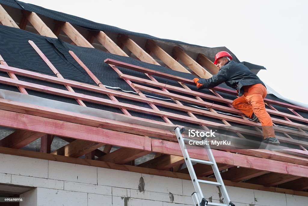 installation of a roof Worker installs bearing laths on the truss system 2015 Stock Photo