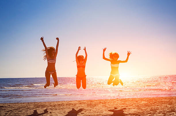 istock Three happy friends jumping on the beach for summer 495699955
