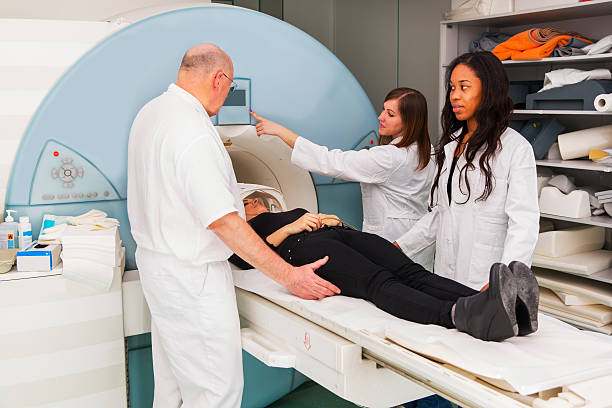 istock Woman patient having MRI scan,assisting chief radiologist,two doctors 495700733