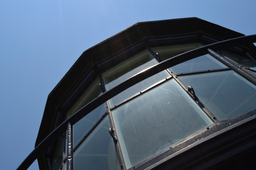 Close up shot of the top window of a lighthouse at a 45 degree angle.