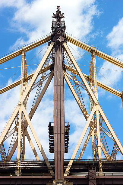 istock Queensboro Bridge bearing close-up details against blue sky with clouds. 495716559