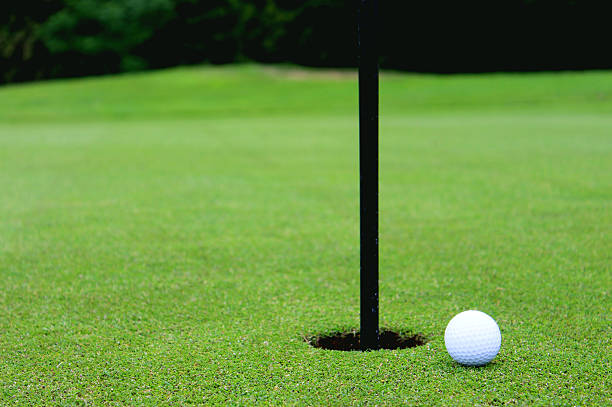 istock Golf ball by hole and flag, putting green, golf course 495717183