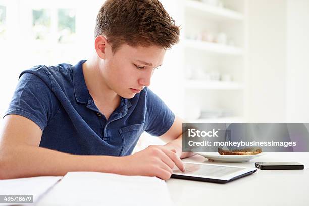 Teenage Boy Studying Using Digital Tablet At Home Stock Photo - Download Image Now - 18-19 Years, Book, Digital Tablet