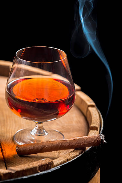 istock Smoking cigar and wooden brandy barrel 495720613