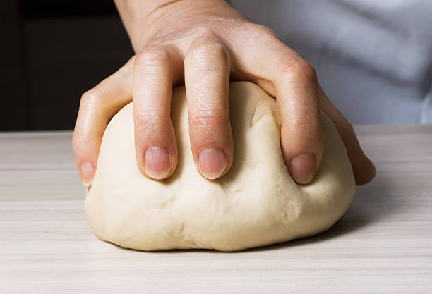 Hands kneading a dough.