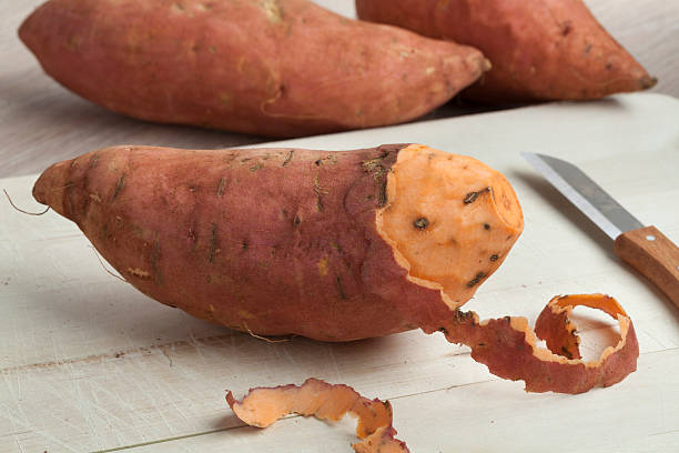 剥いたサツマイモ - root vegetable raw potato human skin root ストックフォトと画像