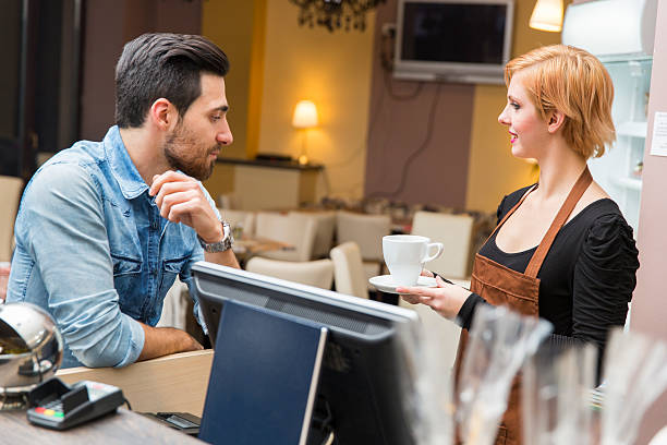 istock Cute waitress serving coffee to a young customer 495729024