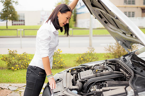 istock Woman looking at broken cars motor 495730266