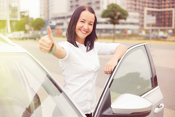 istock Woman standing next to car with thumbs up 495730378