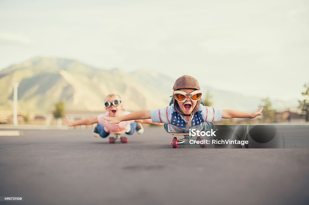 Молодой Мальчик и девочка, представьте, летящий на Скейтборд - Стоковые фото Ребёнок роялти-фри