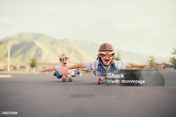 Молодой Мальчик И Девочка Представьте Летящий На Скейтборд — стоковые фотографии и другие картинки Ребёнок