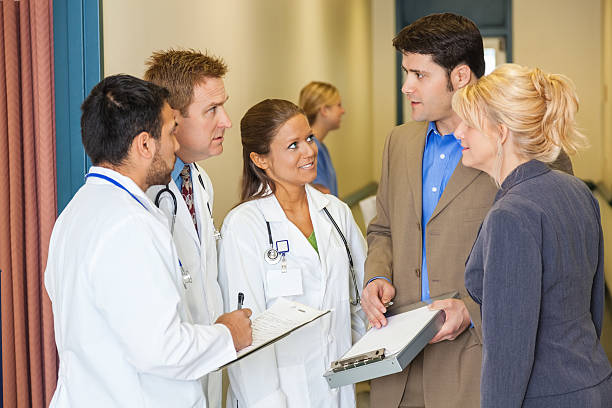 istock Hospital administrators discussing something with doctors in hallway 495731539