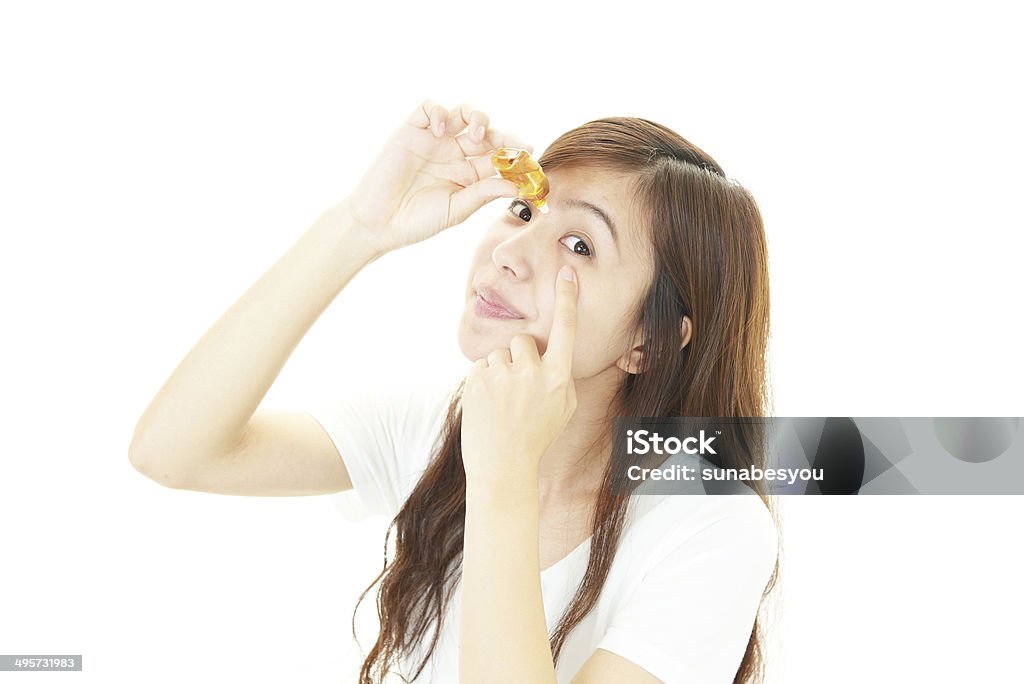 Woman with eyestrain Woman dripping eye with eyes drops Adult Stock Photo