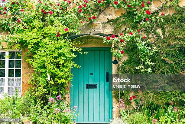 Charming House With Green Doors And Red Roses Stock Photo - Download Image Now - Cottage, Yard - Grounds, Door