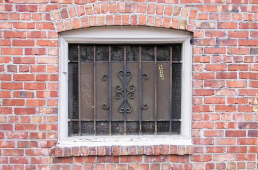 This image shows a brick building in Seattle, with bars on the window for security.
