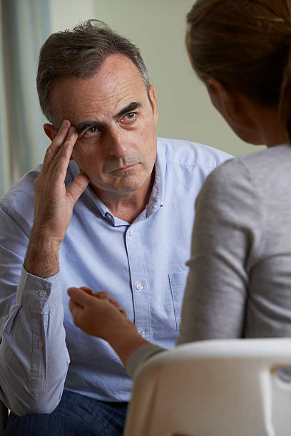 istock Depressed Mature Man Talking To Counsellor 495735964