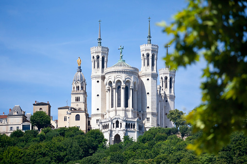 The Basilica of Notre Dame in the Fourviere district of Lyon in the Rhone-Alpes region. Lyon is France’s third largest city. The chapel tower to the left of the basilica is topped with a statue of Mary. Good copy space.
