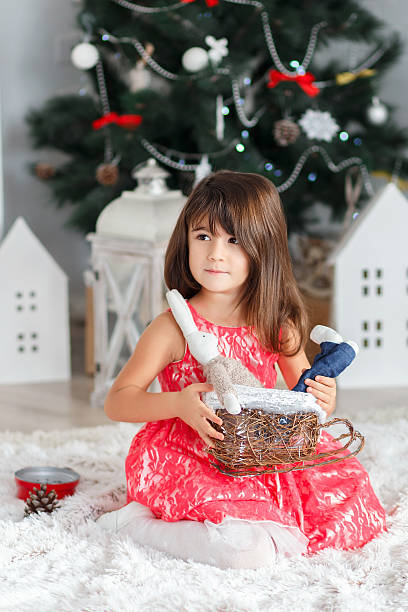 retrato de uma linda menina segurando um pouco brunette brinquedo bunny - clock baby christmas small - fotografias e filmes do acervo