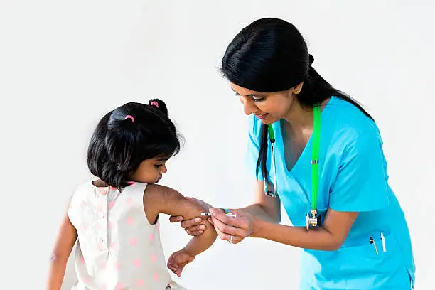 Female doctor giving an injection to the child.