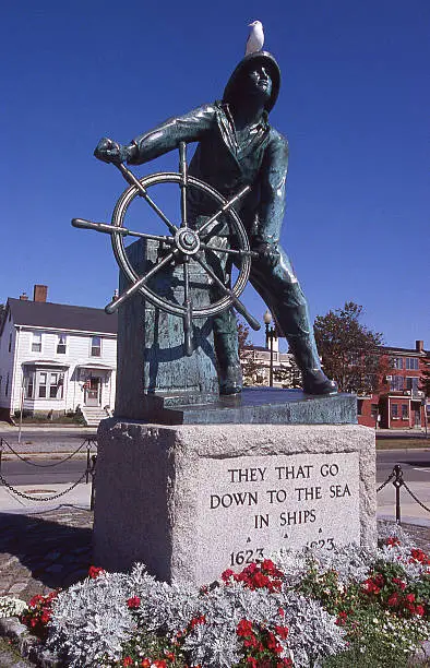 Gloucester Massachusetts Fisherman's Memorial also known as "Man at the Wheel" statue or "Fishermen's Memorial Cenotaph" is an historic memorial cenotaph sculpture on South Stacy Boulevard near entrance of Stacy Esplanade in Gloucester Massachusetts built in 1925