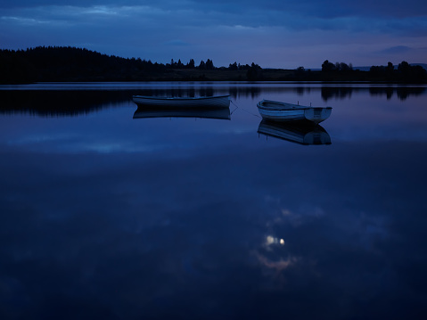 A view of loch Rusky in the trossachs of Scotland after sunset and lit by moonlight.