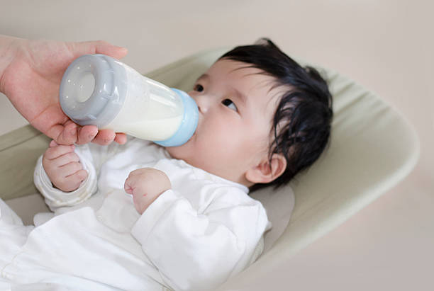 istock feeding milk with baby bottle 495744913