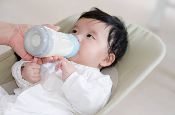 istock feeding milk with baby bottle 495744929