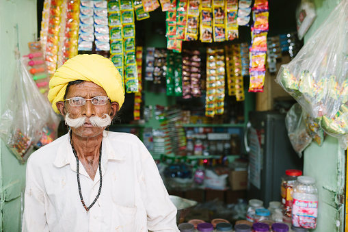 Senior man at his kiosk, Sabbalpura village, Rajasthan, India. 