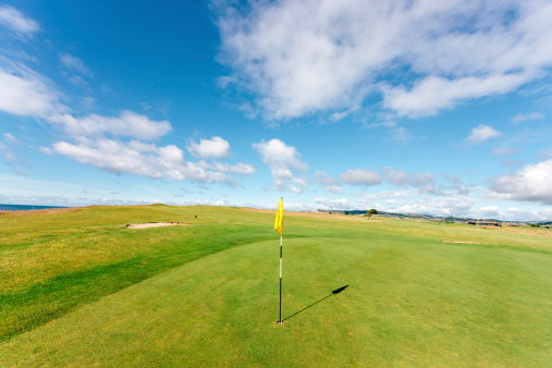Yellow green flag on a beautiful coastal links golf course in Dorset. Bridport Golf Club, Bridport, Dorset. 