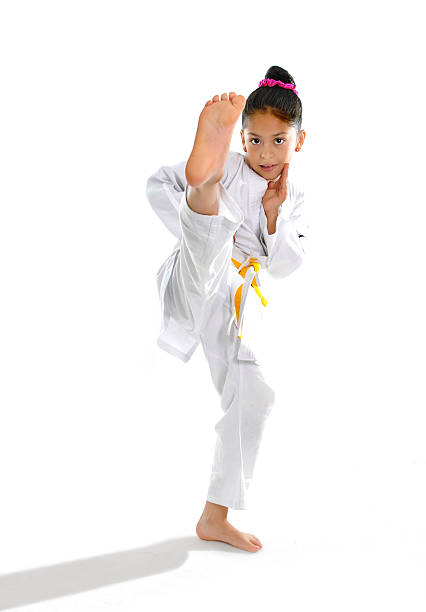 adorable petite fille en kimono de karaté formation kick attaque - child sport karate education photos et images de collection