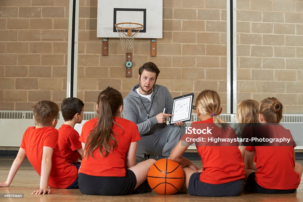 Entrenador personal que hable del equipo de básquetbol de la escuela primaria - Foto de stock de Entrenador libre de derechos