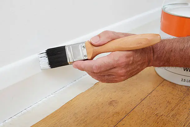 Photo of Close Up Of Man Painting Skirting Board