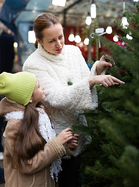 istock mother and daughter choose tree 495755054