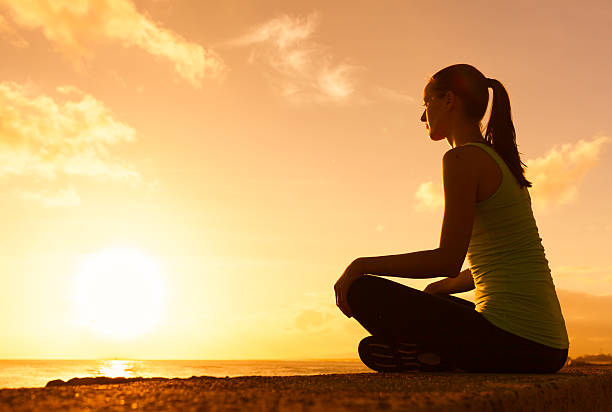 istock Woman meditating on the beach 495755514