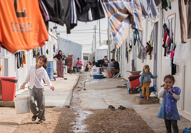 Dohuk, Kurdistan/Iraq - October 08, 2015: Mothers and children in an IDP camp. They are sittingi in front of the containers, where they live now. The camp is located in the mountains close to the turkish border.