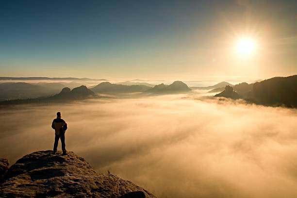 istock Man stands on peak and watching to Sun. Beautiful miracle 495757388