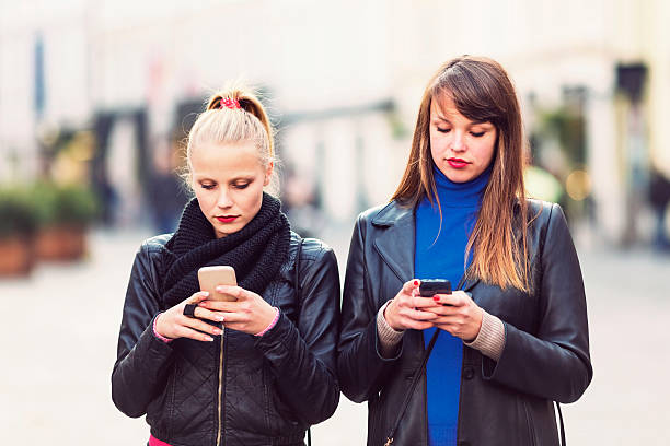 istock Young women text messaging, bored 495758142