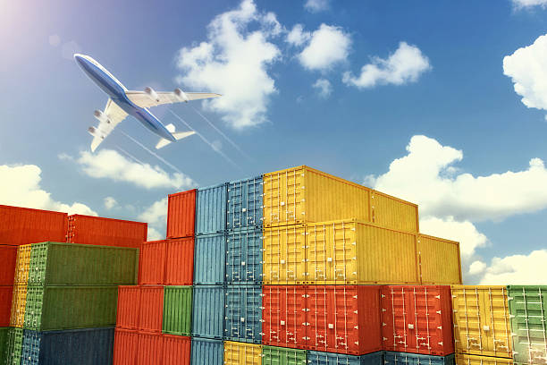 istock Cargo airplane flying over stacked shipping containers 495759016