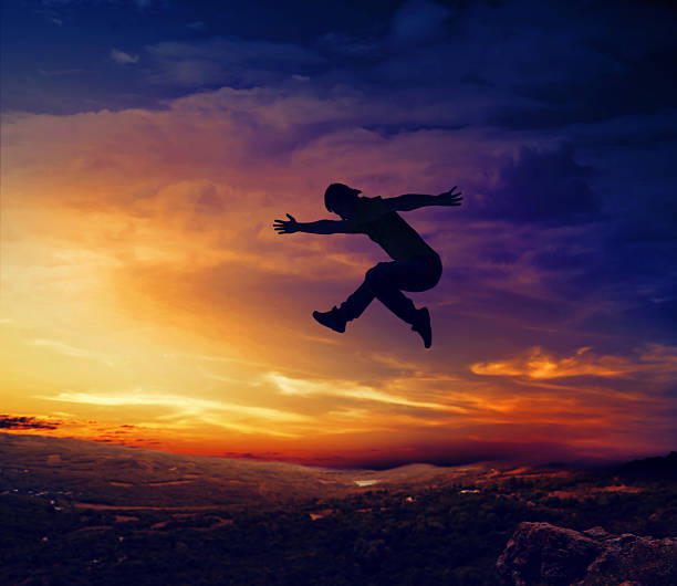 istock Silhouette of man jumping off a cliff 495761209