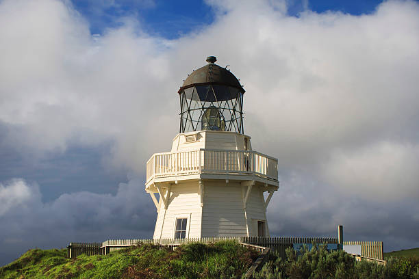 The famous snow-white lighthouse of Waipapa is visible on the horizon. Scenic South Island on a cloudy windy day. Independent trip to New Zealand. The concept of ecological, active and photo tourism