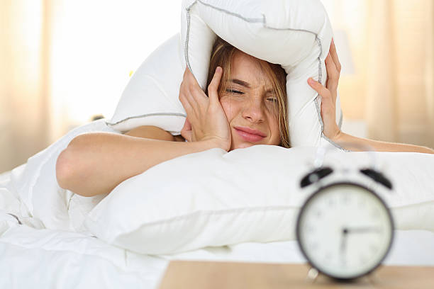 jovens bonitas mulher deitada na cama loura - clock face fotos imagens e fotografias de stock