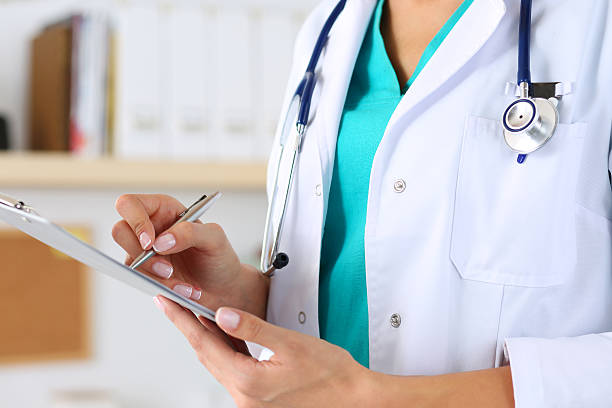 Female medicine doctor hand holding silver pen Female medicine doctor hand holding silver pen writing something on clipboard closeup. Medical care, insurance, prescription, paper work or career concept. Physician ready to examine patient and help anamnesis stock pictures, royalty-free photos & images