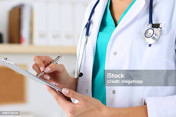 Female Medicine Doctor Hand Holding Silver Pen Stock Photo - Download Image Now - Doctor, Clipboard, Medical Student