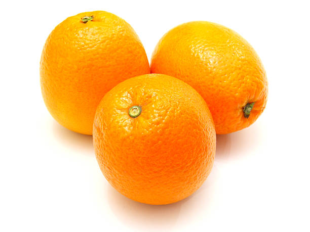 istock Three ripe oranges lie nearby on a white background 495774322